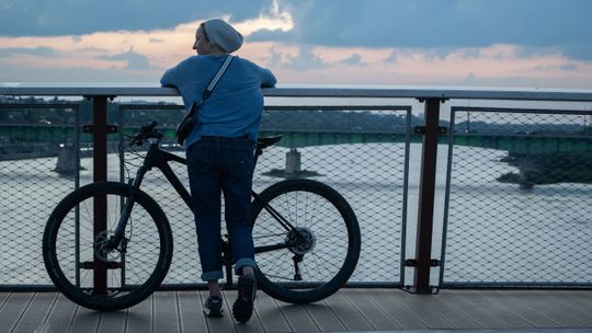 Kobieta przy rowerze nad Wisłą.