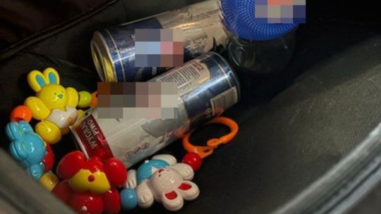 Piwo obok zabawek w wózku miesięcznego chłopca.